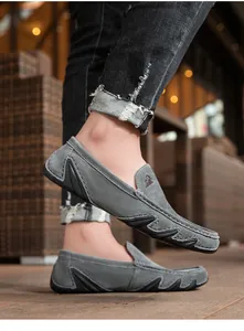 Détail de mocassins en daim gris avec surpiqûres blanches et accents en caoutchouc