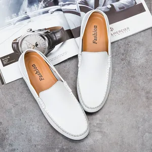 Detailed close-up of white leather loafers with premium stitching on a textured background