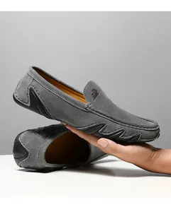 Détail du mocassin en daim gris avec coutures et semelle ondulée en caoutchouc