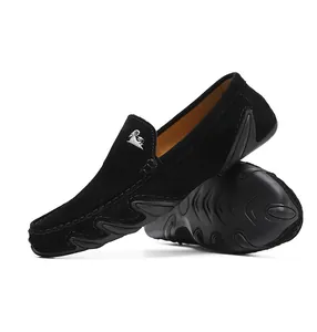 Détail de mocassins en daim noir avec picots antidérapants et logo de chèvre