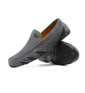 Détail de mocassins en daim gris avec semelles en caoutchouc et doublure orange vif