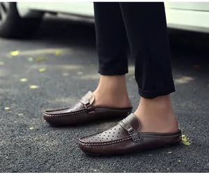 Makro-Detail brauner Leder-Mules für Herren mit Perforation und weißen Kontrastnähten