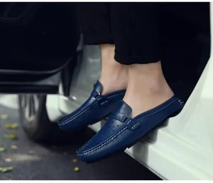 Details von dunkelblauen Leder-Mules mit weißen Nähten und atmungsaktiver Lochung