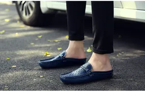 Detail von dunkelblauem Leder-Slipper mit atmungsaktiven Löchern auf Asphalt-Hintergrund