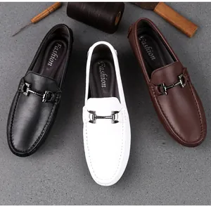 Nahaufnahme von Leder-Loafers in Schwarz, Weiß und Braun mit Metall-Zierschnalle