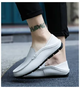 Close-up of white leather loafers showing lychee grain texture and rubber driver sole