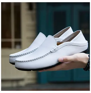 Close-up of white leather loafers featuring handmade stitching and anti-slip rubber soles