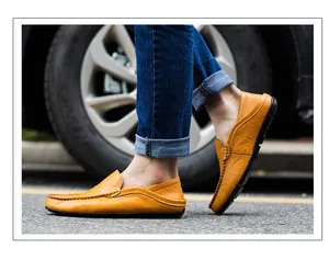Macro side view of yellow leather loafers with contrast stitching and split rubber sole