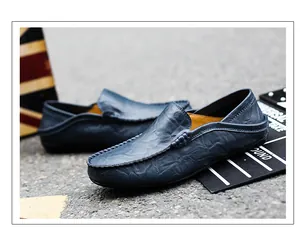 Detail of hand-stitched seams on dark blue leather loafers with soft cowhide texture