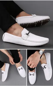 Details weißer Leder-Slipper mit Metallschnalle und Gummikörnersohle am Fuß