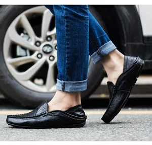 Close-up of black leather loafers for men shown in an outdoor driving scene