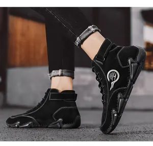 Détail de bottines en daim noir avec coutures blanches et semelle crantée antidérapante