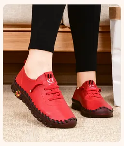 Dettaglio di scarpe basse in pelle rossa con cuciture nere e suola in gomma resistente