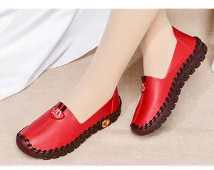 Detail of red leather loafers with handmade stitching and non-slip rubber sole