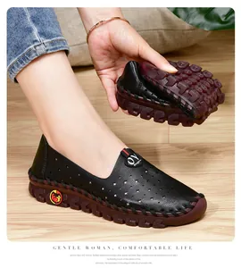Detalle de la suela de goma roja flexible y cuero negro perforado de los zapatos planos de mujer