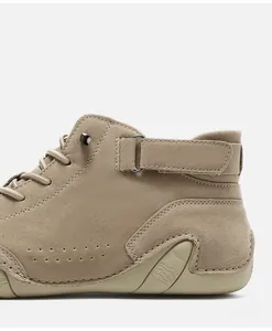 Detail of khaki suede boots with velcro ankle strap and metal buckle fastening