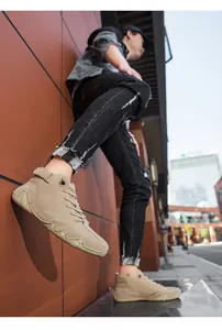 Outdoor low-angle shot of khaki suede high-top casual boots with buckle and rubber sole