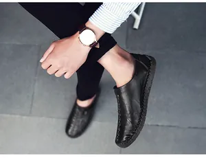 Détails de coutures faites main sur mocassins en cuir noir pour hommes portés par un mannequin