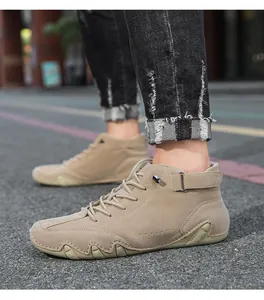 Detail view of men's khaki high-top casual boots with velcro strap and wavy sole