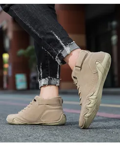 Detail of khaki suede high-top boots featuring velcro strap and non-slip rubber sole