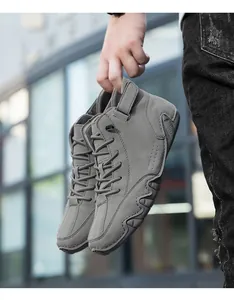 Close-up of grey high-top men's boots with rugged rubber soles and fine stitching