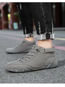Detail of grey high-top sneakers with velcro strap and wave-patterned rubber sole