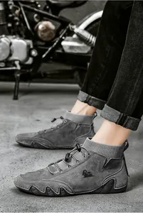 Detail of grey suede mid-top boots with knit collar and wave pattern rubber sole