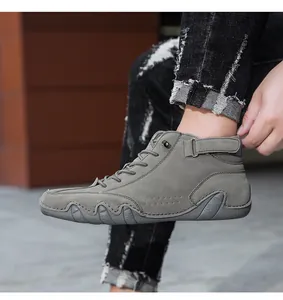 Detail view of dark grey suede high-top boots with laces and ankle velcro straps