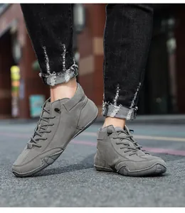 Close-up of grey leather high-top casual sneakers with durable rubber soles and laces