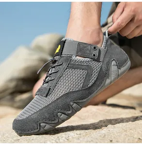 Vista laterale dettagliata di scarpe da trekking grigie traspiranti su una spiaggia