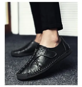 Détail latéral des mocassins en cuir noir avec coutures à la main et semelle en caoutchouc