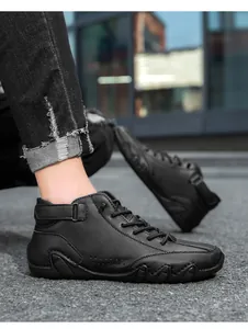 Close-up of black leather high-top shoes with buckle strap and serrated rubber sole