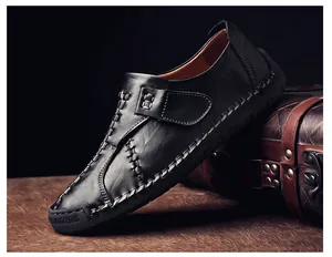 Détail de mocassins en cuir noir faits main avec coutures contrastées et boucle élégante
