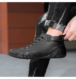 Detail of black leather casual high-top boots with lace-up and velcro strap closure