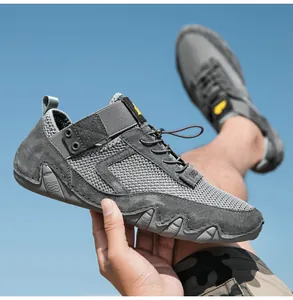 Dettaglio di scarpe da uomo in mesh grigio scuro con suola in gomma e sfondo di cielo aperto