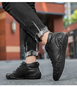 Outdoor street view of black high-top casual leather sneakers with velcro strap and laces