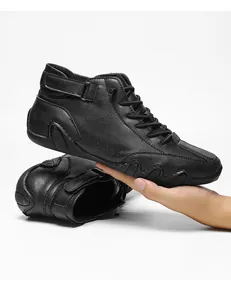 Detail of black high-top casual sneakers featuring leather texture and velcro strap