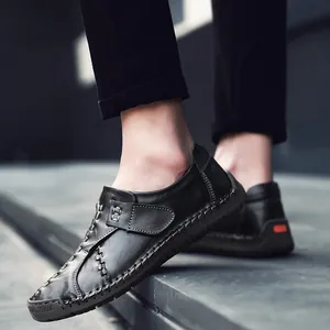 Mocassins pour hommes en cuir noir avec coutures décoratives sur un escalier
