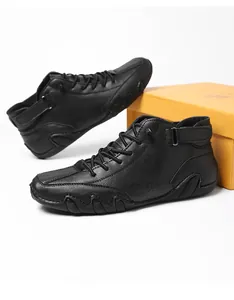 Detail view of black high-top casual shoes with wavy rubber sole and velcro strap