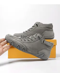 Detail of high-top men's casual boots in dark grey suede with velcro strap and rubber sole