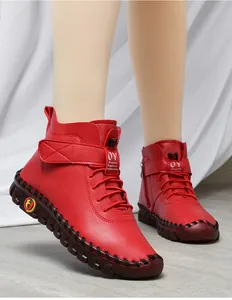 Detail view of red winter boots featuring decorative stitching and sturdy rubber soles