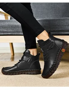 Detail of handmade stitching on black leather ankle boots with non-slip thick rubber soles