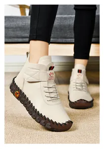 Close-up of beige high-top women boots with thick rubber soles and hand-stitched details