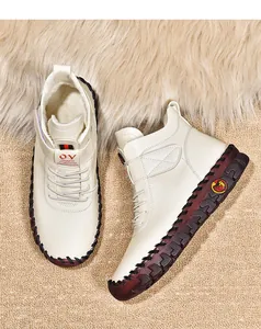 Detail of warm beige faux leather boots with fleece lining and manual stitching