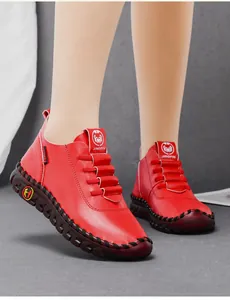 Detailed close-up of red leather flat shoes featuring hand-stitched seams and soft sole