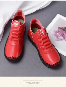 Detail of red leather loafers with black hand-stitched seams and elastic laces
