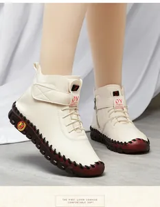 Detail of premium off-white leather boots with stitching and thick red textured sole