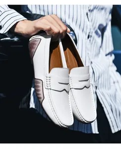 Detail of white leather loafers featuring a moccasin stitch and textured pebble finish
