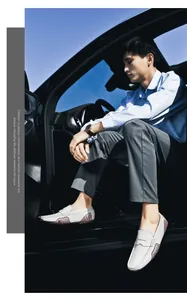 Detail of white leather loafers featuring breathable brown cutouts worn in a car