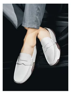 Macro detail of white pebble leather loafers with hand-stitched seams and grip rubber sole